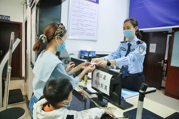 林女士領(lǐng)取兒子的第一張居民身份證。重慶市公安局治安管理總隊供圖