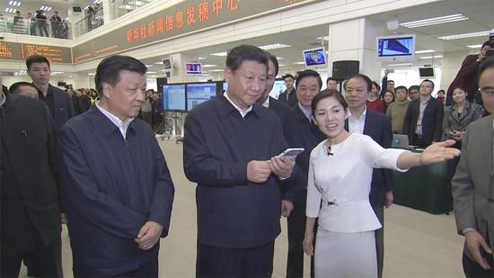 在新華社新聞信息發(fā)稿中心，習(xí)近平通過手機(jī)移動平臺為新聞工作者點(diǎn)贊。