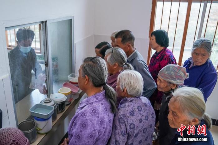 資料圖:廣西隆安縣東信村“爸媽食堂”內,老人們排隊取餐。 <a target='_blank' >中新社</a>記者 陳冠言 攝 點擊進入下一頁
