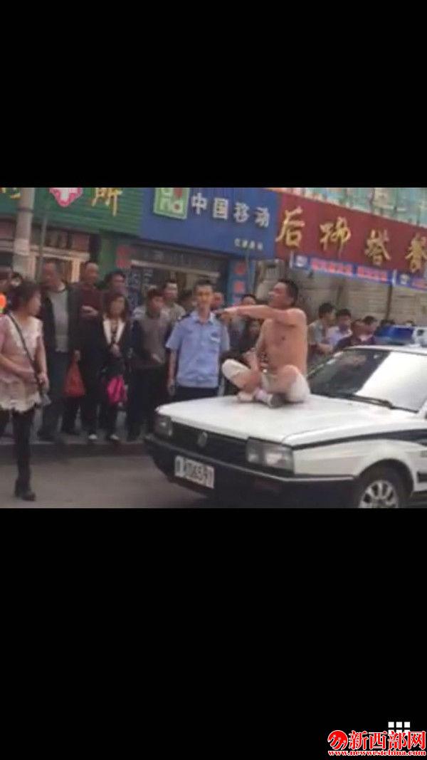 醉漢楊某坐在警車車頭辱罵民警和路人_副本.jpg